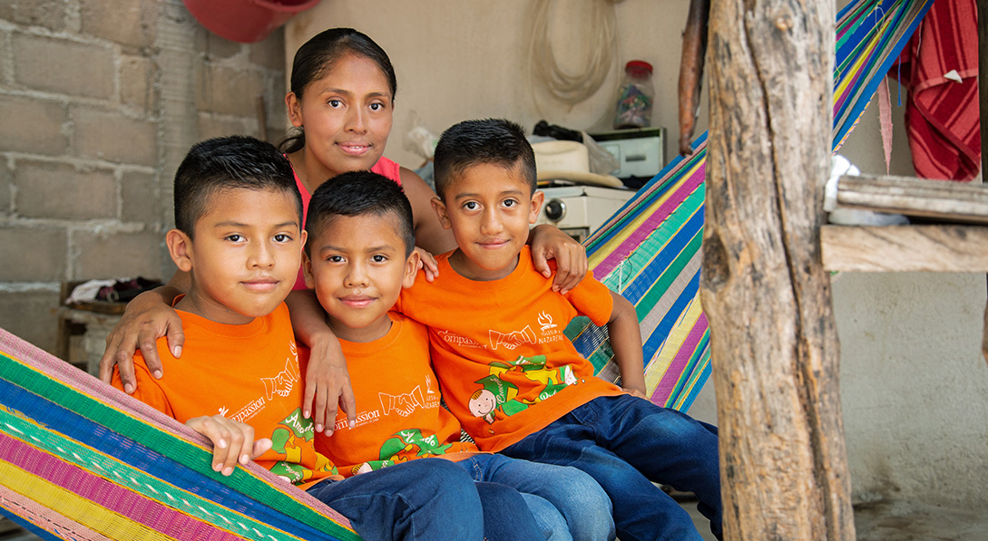 Iker and his brothers sit on a hammock with their mother