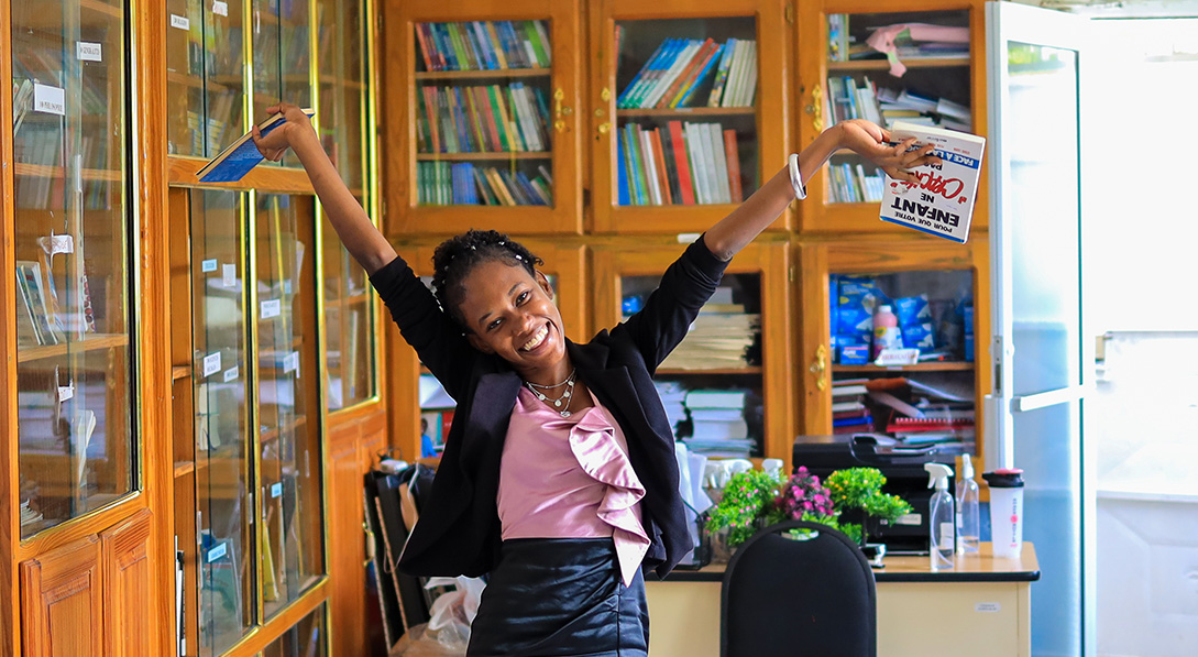 Taina holds some books in her center's library