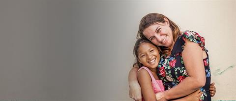 A woman and young girl hug