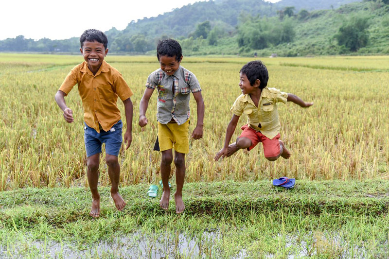 Young boys laugh while jumping in water