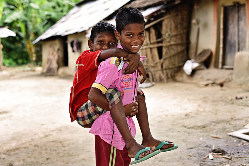 A young boy carries his brother on his back