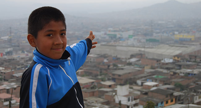 Boy pointing towards city