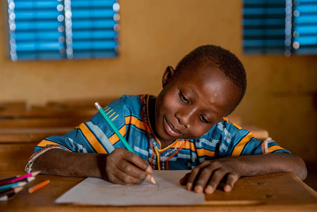 A boy writing a letter at a desk