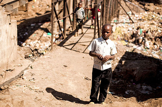 Boys walking across a trash collection area