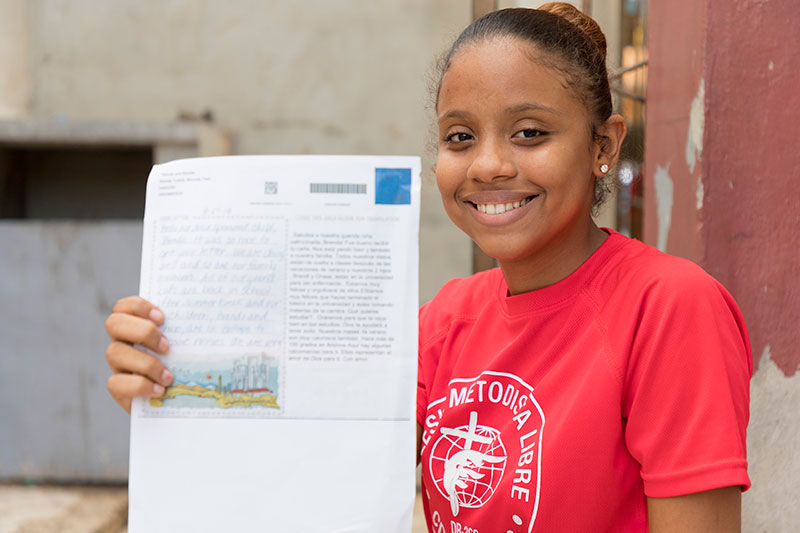 a girl smiles holding a letter