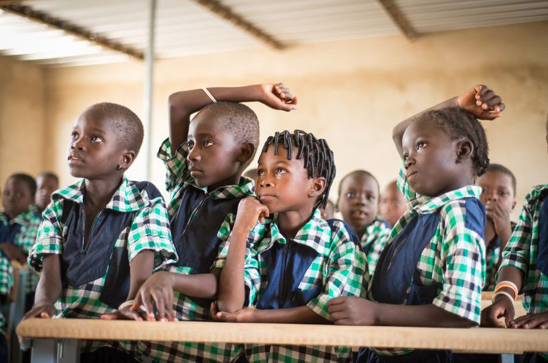 Children raise their hands to answer a question in class