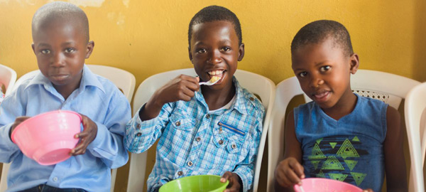 three boys enjoying a snack