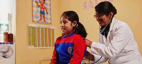 A girl receiving a health exam by a medical professional