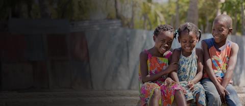 Three children in the Dominican Rrepublic sit together