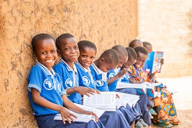 A man helps children in a classroom