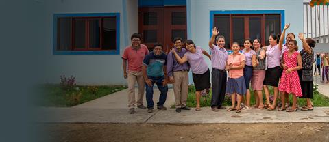 A group of children smiling in front of a church