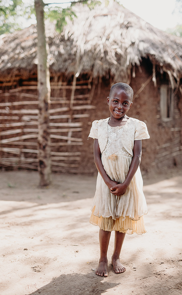 a girl stands in front of her home