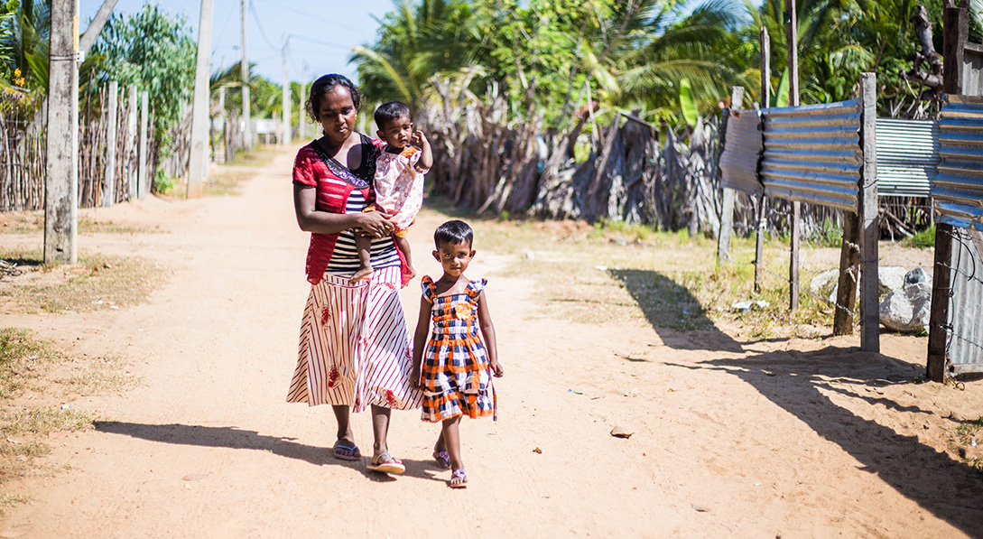 Udea walks down the street with her children