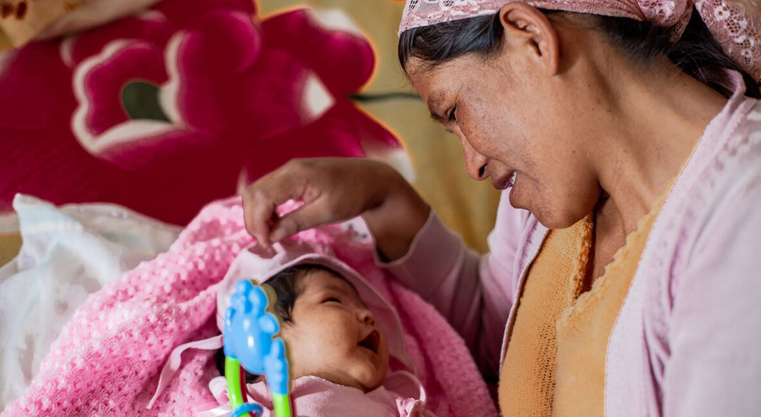 a woman looks at her newborn baby