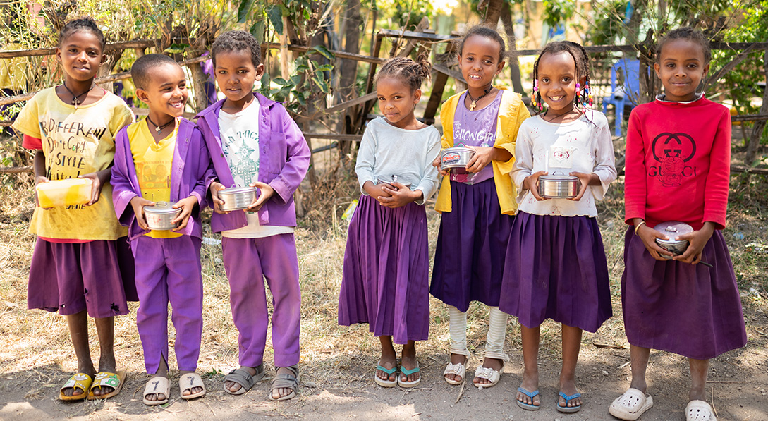 several young girls hold their new lunchboxes