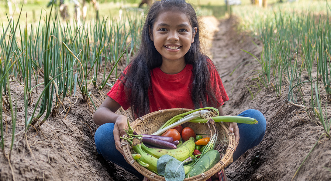 Juna holds a basket of vegetables