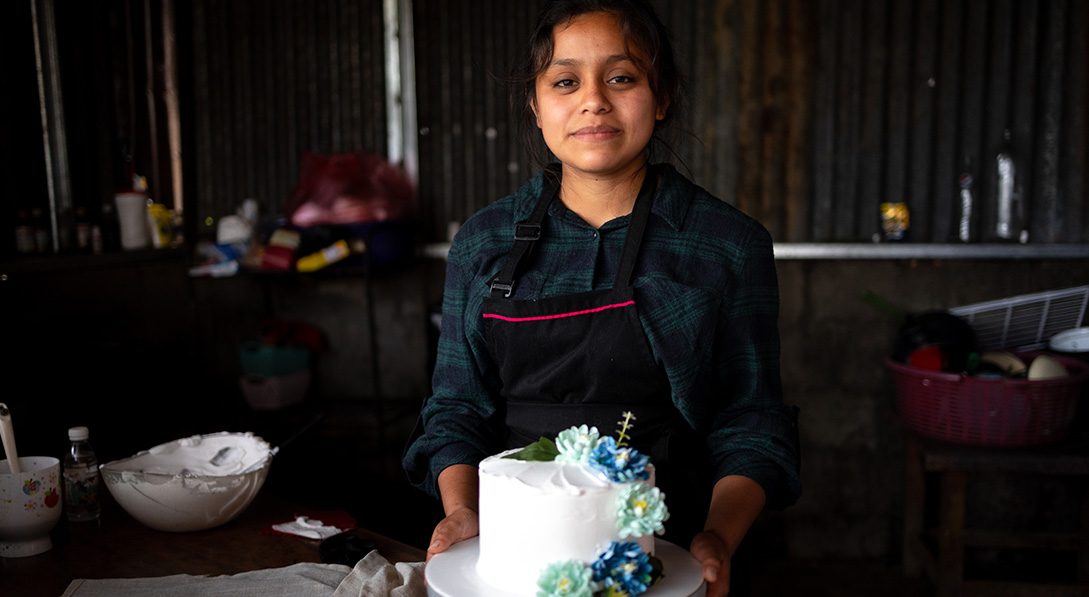 Delmy, who owns a baking business, shows a coffee and cream cheese cake she made.