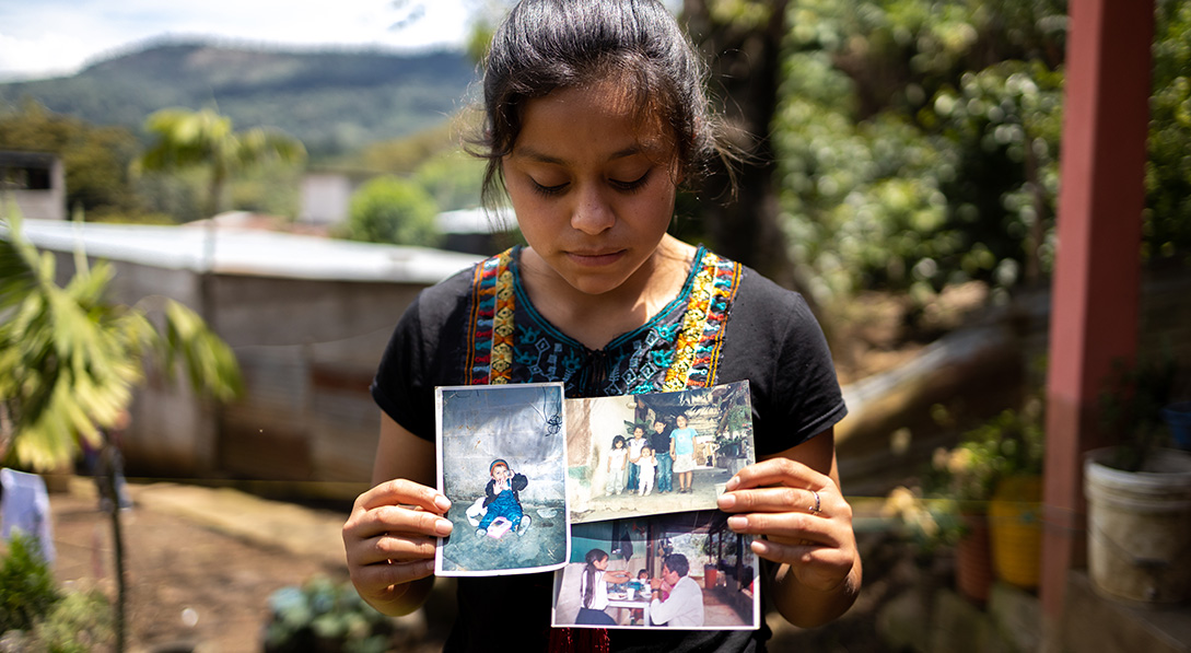 Delmy holds photos of when she was little with her sisters and late father.