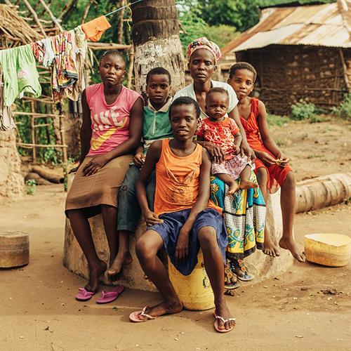 a family sits outside their home