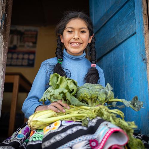 a girl holds a tray of vegetables