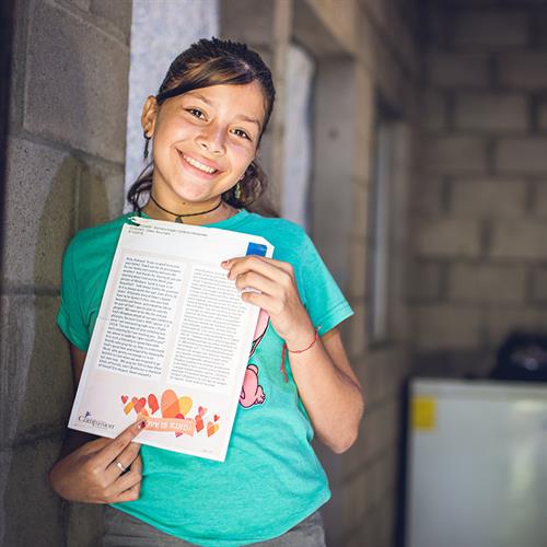 a girl holds a letter from her sponsor