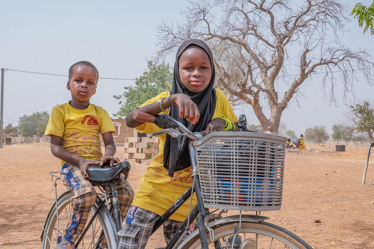 2 children ride a bicycle