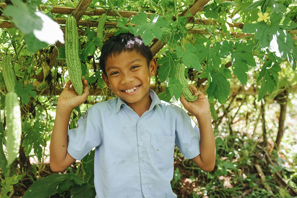 Boy stands in front of garden