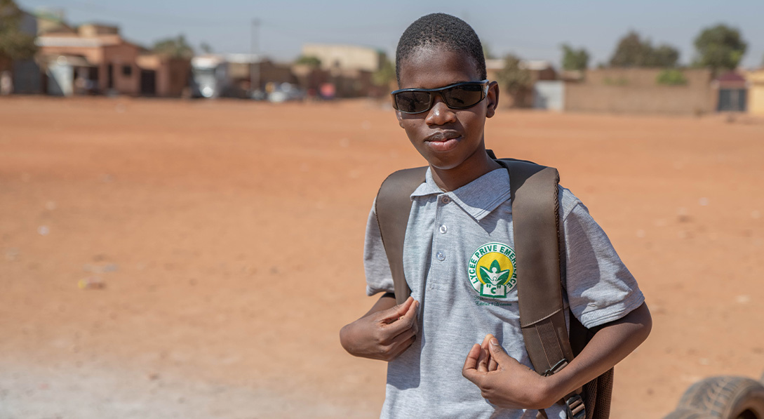 Kader on his way to school carrying backpack