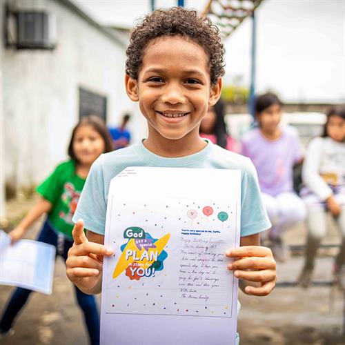 a boy hold up a letter