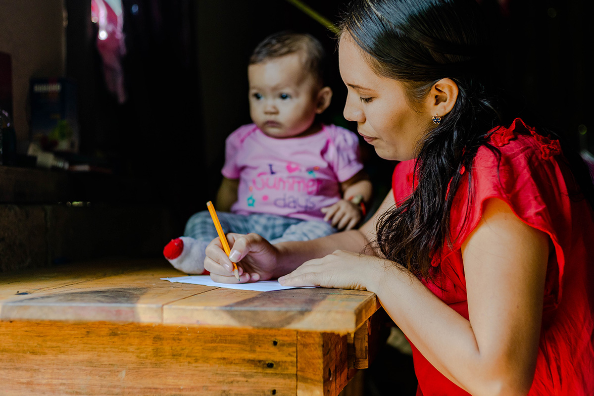 Mother writes letter with child