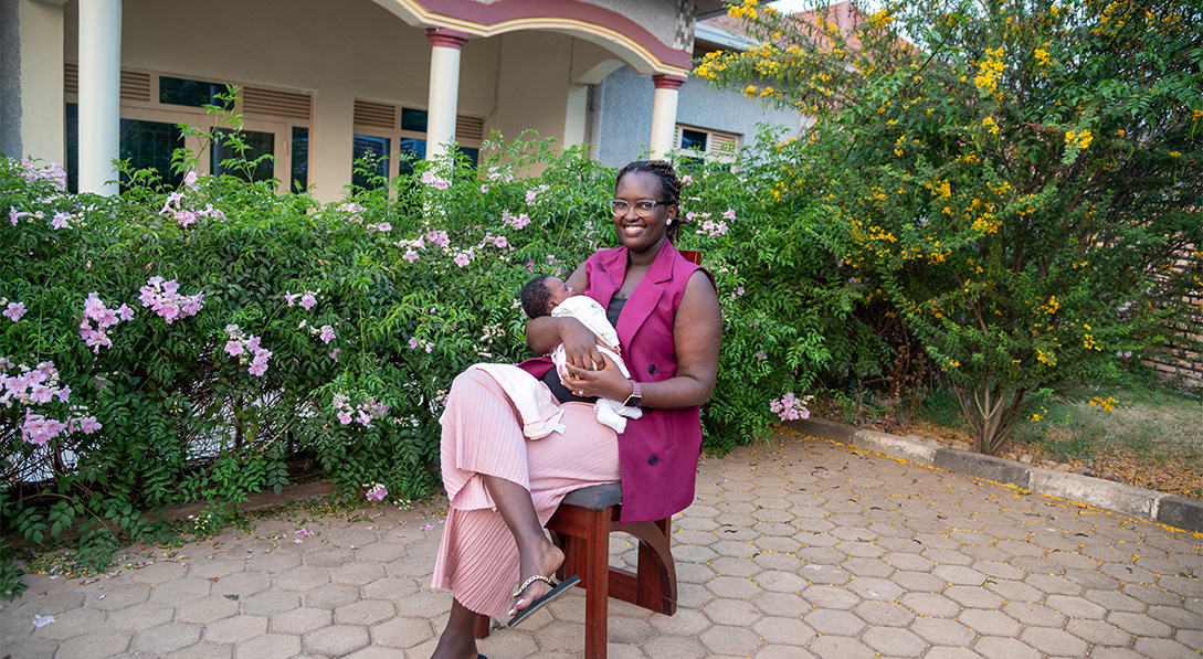 Sharon holds baby and smiles at camera 