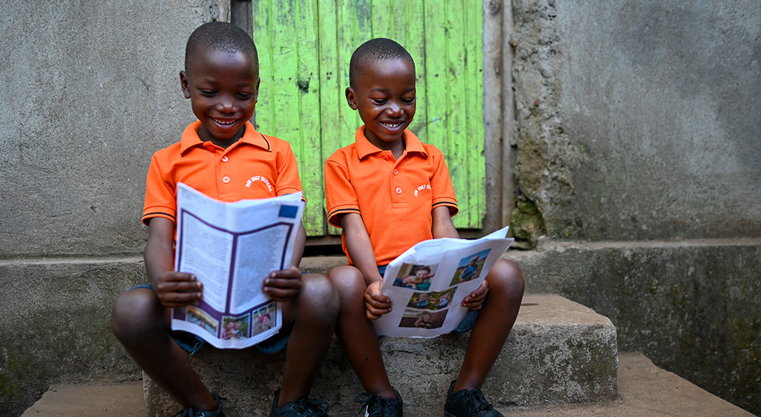 Twins hold letters and smile 