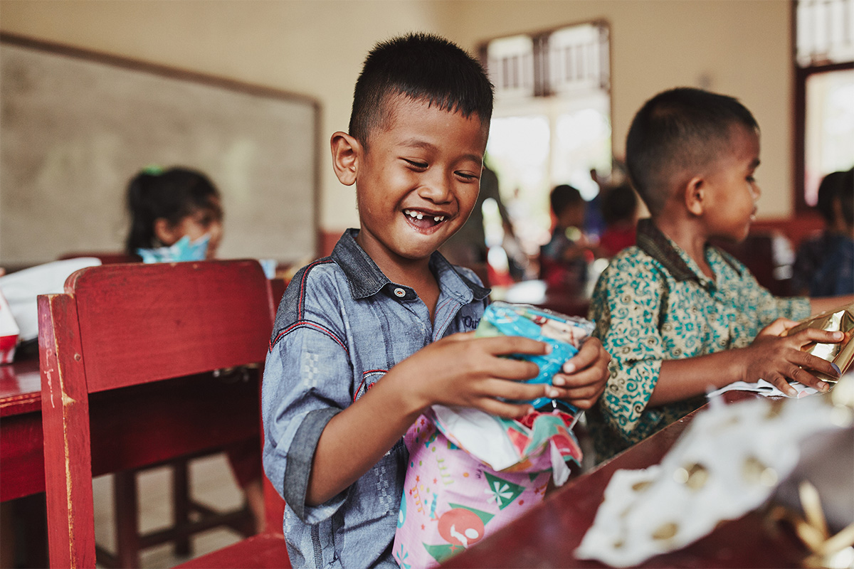 boy smiles while holding gift