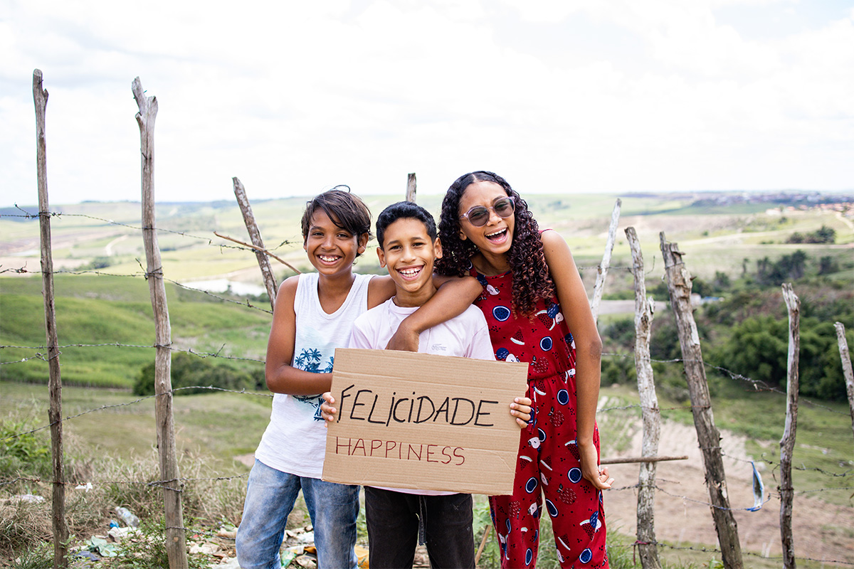 children smile while holding sign