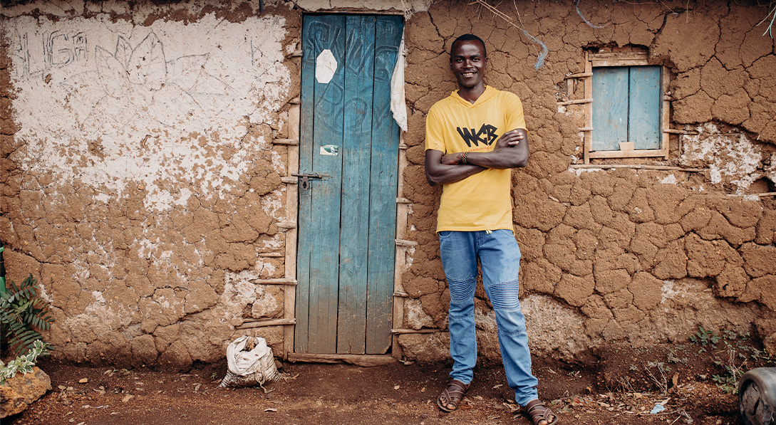 Maisha outside one of the homes he built.