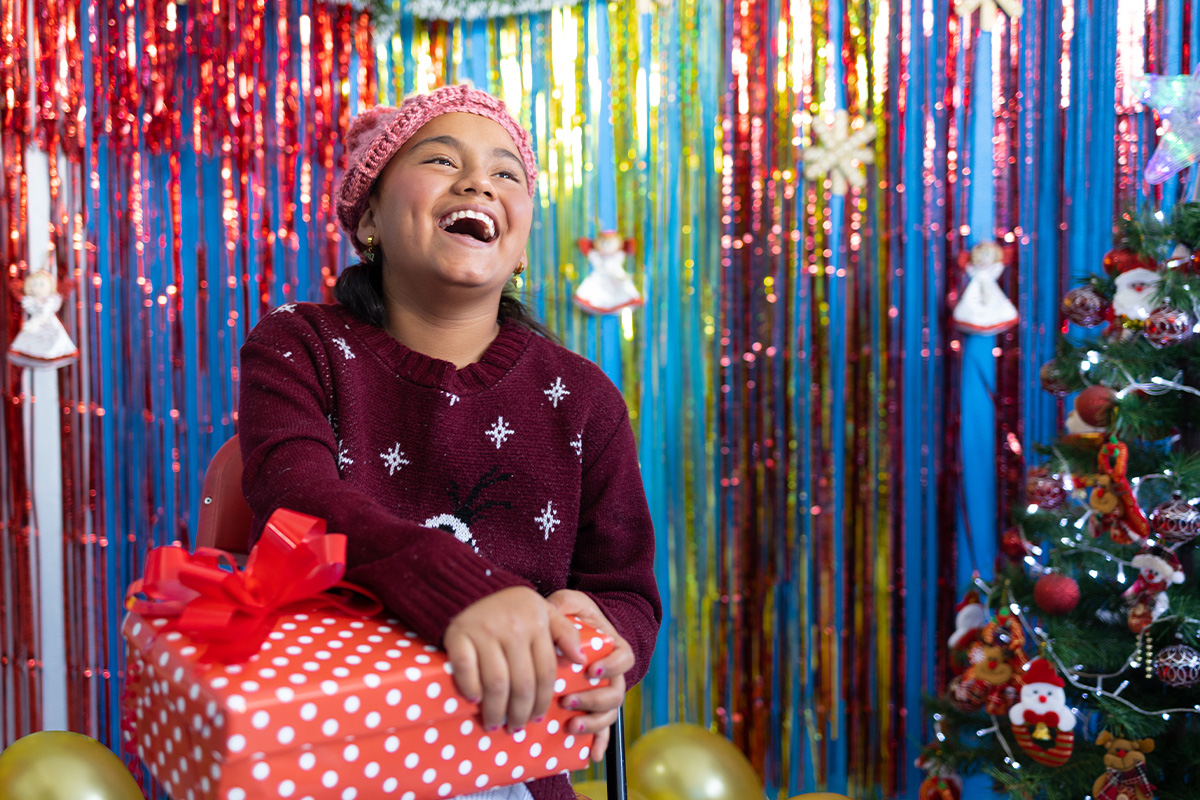 Meydeline smiles while holding gift