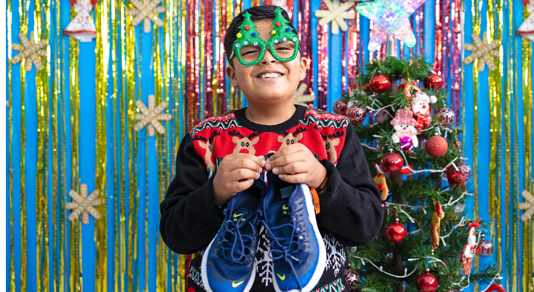 Eitan exictedly holds pair of shoes