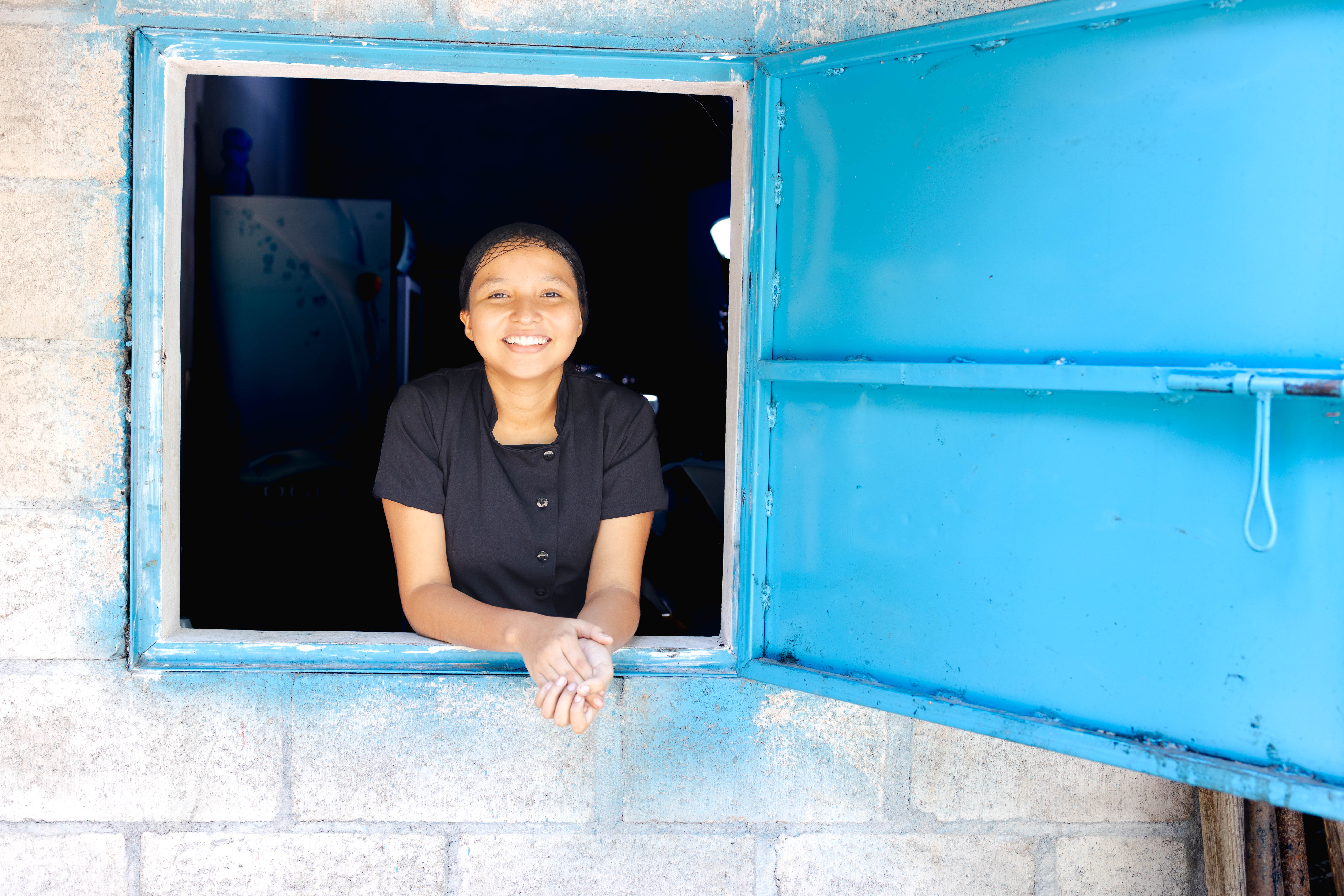 Girl looks out blue window