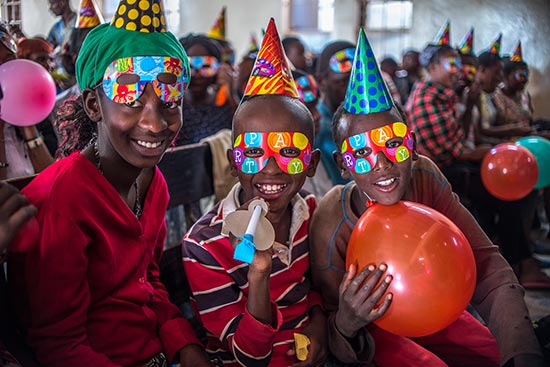 children wearing party hats and party masks