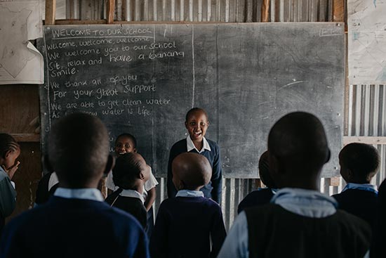 A student stands at the front of class leading other students in an activity