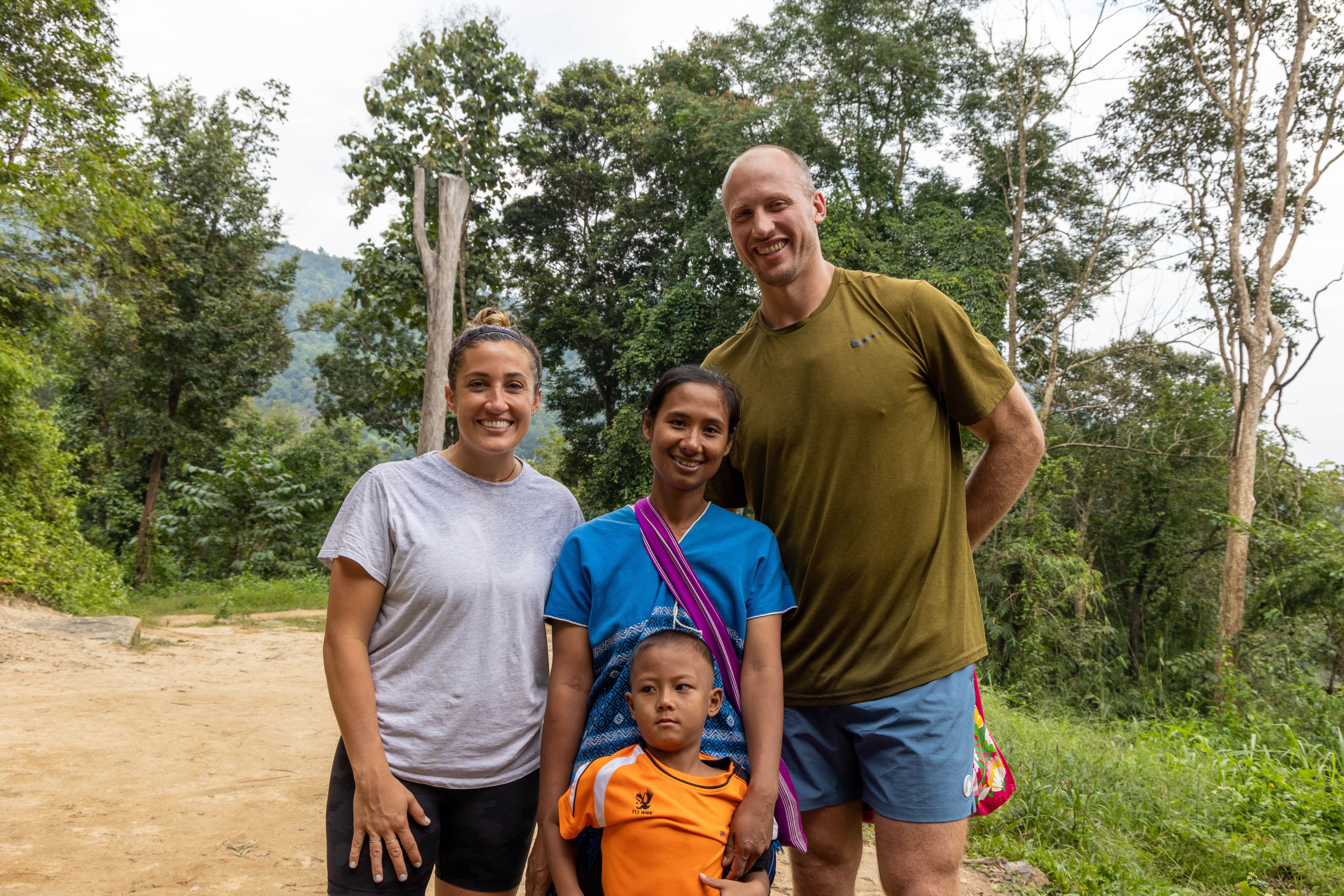 Pro athlete poses for photo with woman and child from Thailand