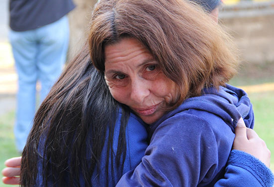 An older woman received a hug from another woman