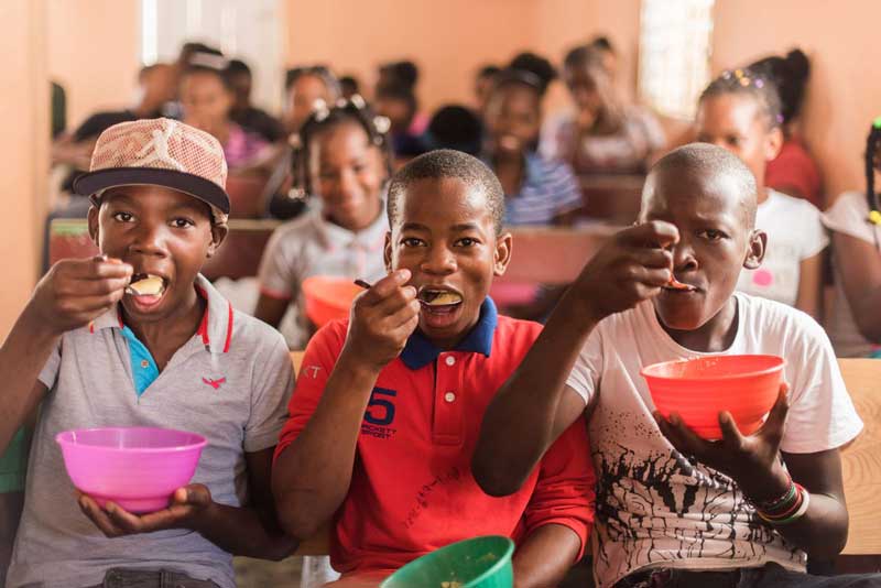 Teenage boys eat a nutritious meal together at their child development center