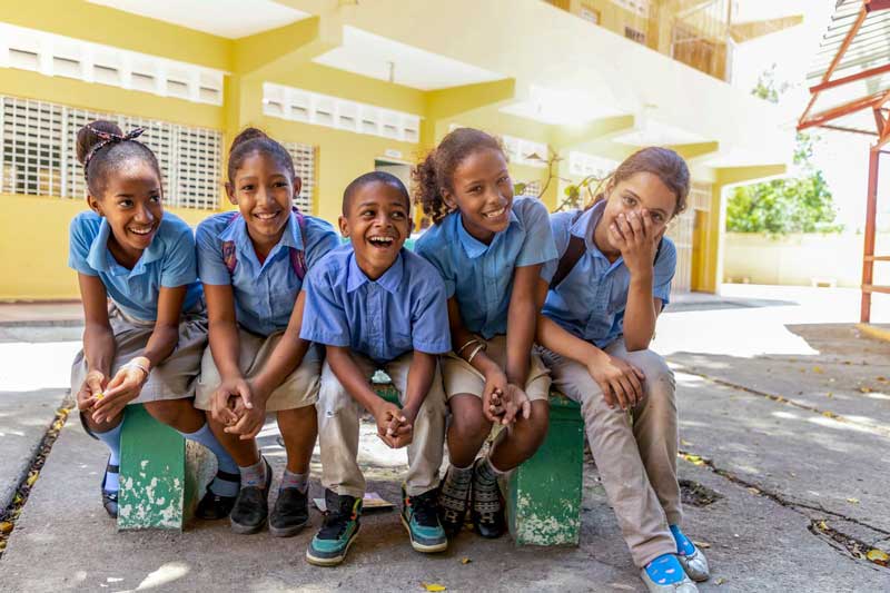 A group of children laugh together at their child development center