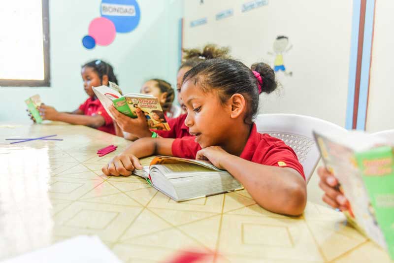 Children read their Bibles together at their child development center