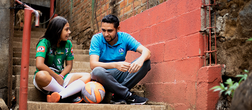 a girl talks with her soccer coach