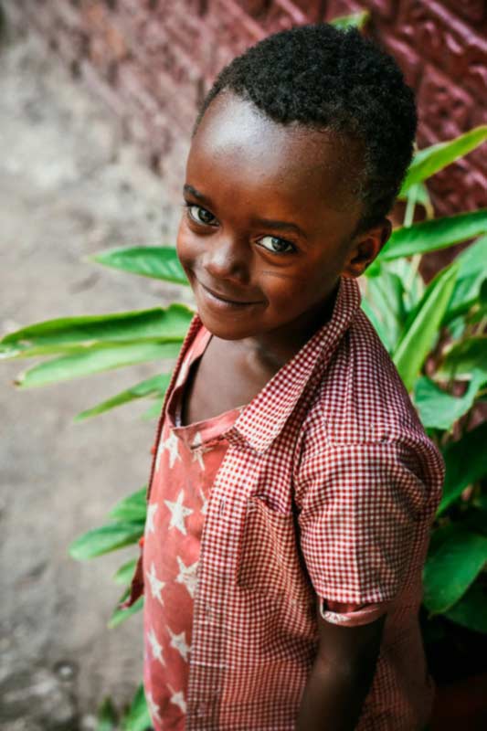 A boy wearing a red shirt smiling