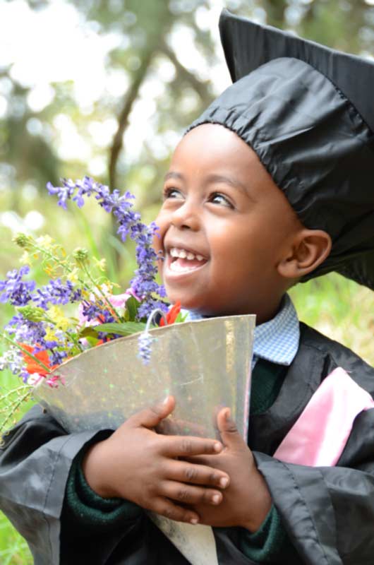 A young boy celebrating his transition into the Child Sponsorship Program