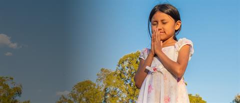 a girl stands and prays