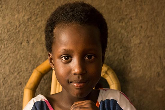 A girl sitting in a chair with hands folded